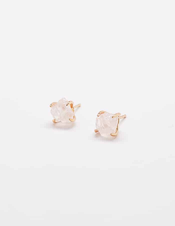 Rose quartz gold claw stud earrings with soft pink stones, worn on ear with a minimal, refined jewelry aesthetic.
