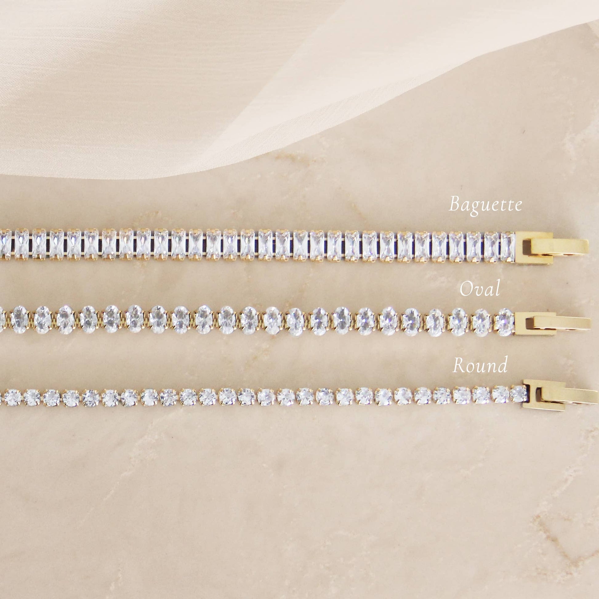 Minimal CZ tennis bracelet in gold over surgical steel, featuring a refined, understated design styled on a neutral marble surface.