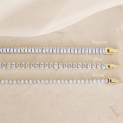 Minimal CZ tennis bracelet in gold over surgical steel, featuring a refined, understated design styled on a neutral marble surface.