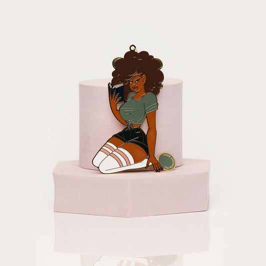 Enamel bookmark of Black woman with curly hair reading a book
