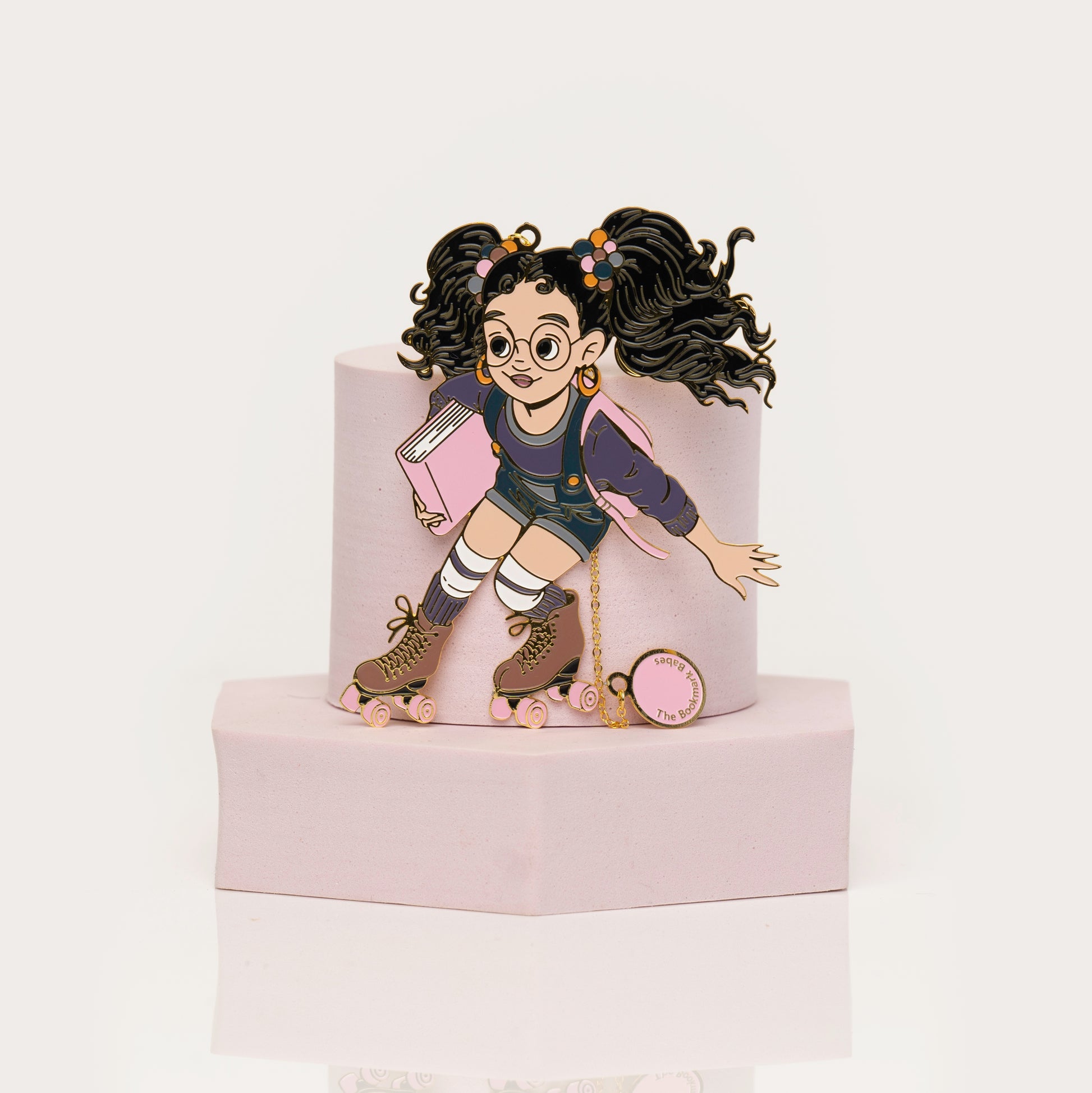 Enamel bookmark of Black girl on rollerskates holding a book
