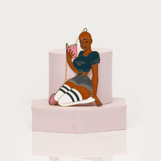 Feminine enamel bookmark featuring bold bald character with book
