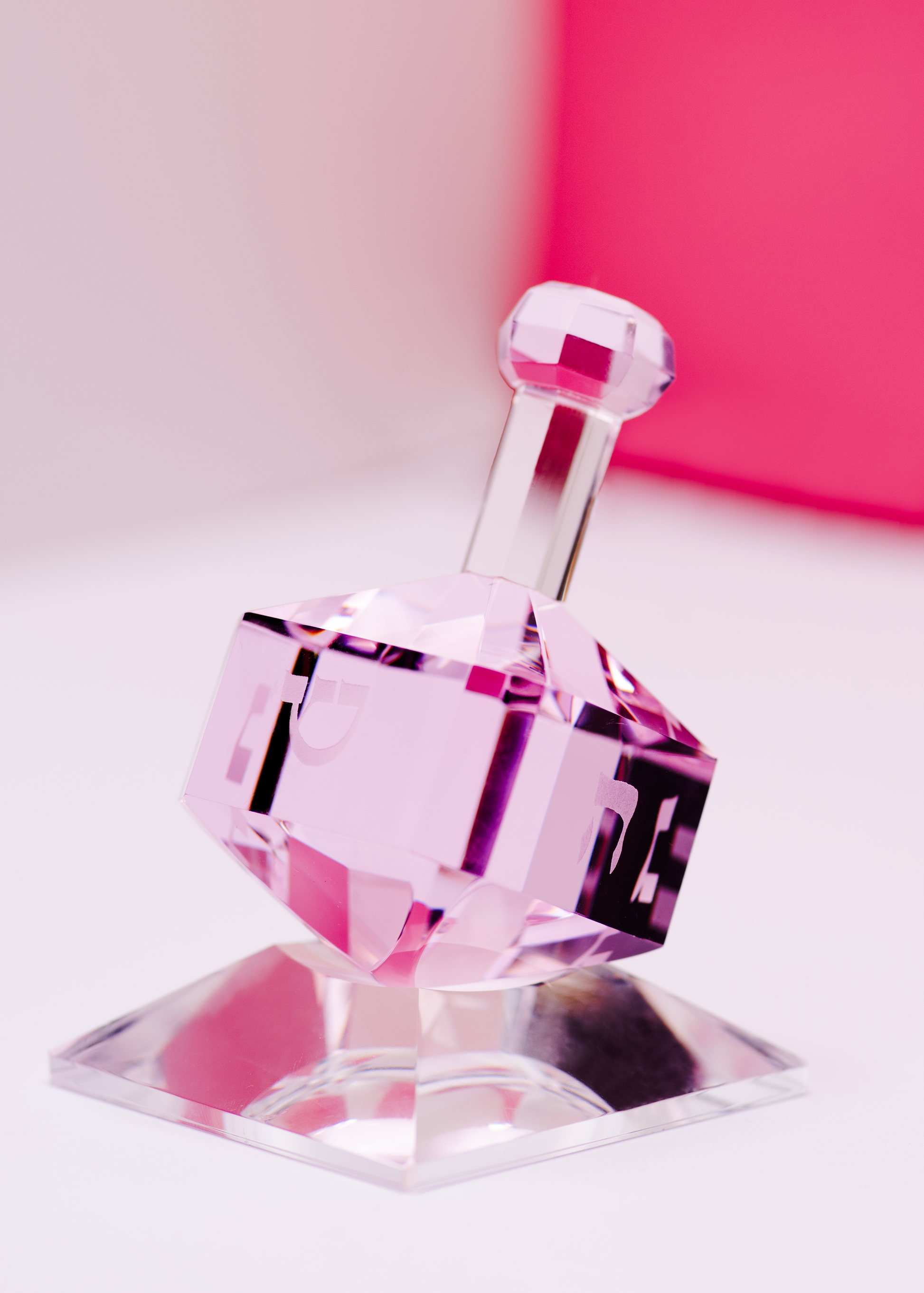 Luxury pink dreidel on clear base, elegant Jewish holiday tabletop decor